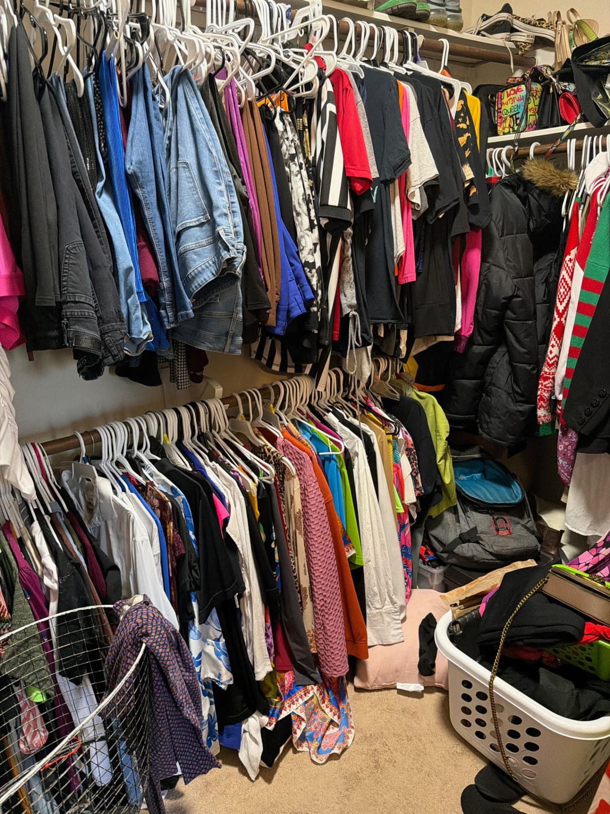 Closet packed with hanging clothes and baskets