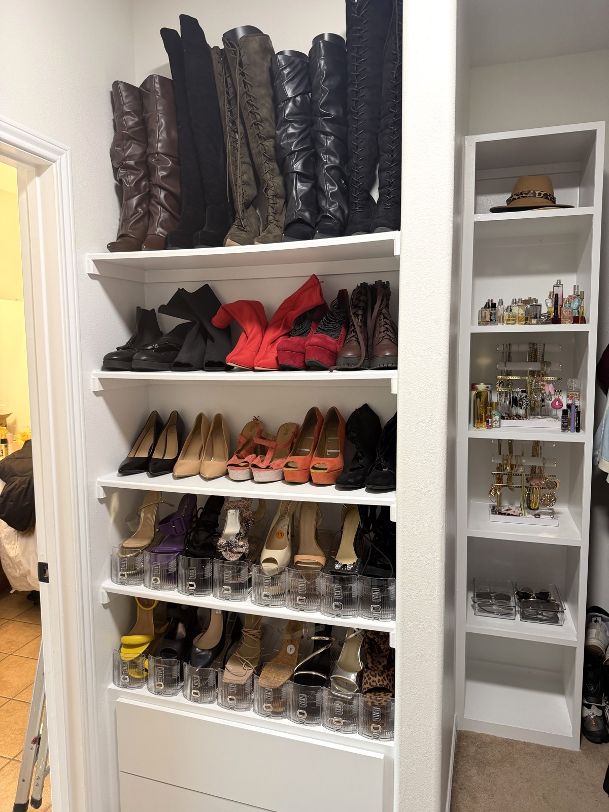 Shoe wall with boots and heels neatly arranged on white shelves